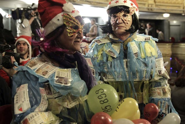 Two women display 'El Gordo' lottery tickets on their bodies as they wait for the beginning of the draw at Madrid's Teatro Real 