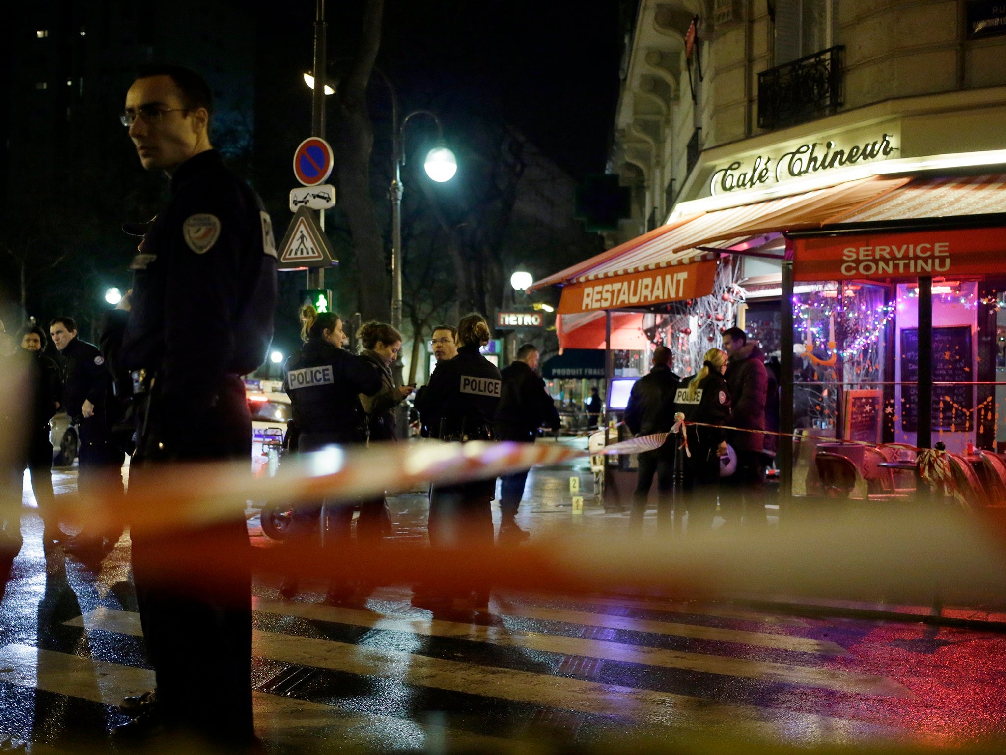 French police investigate at a restaurant in southern Paris on December 22, 2013 where a man and a woman were shot dead at close range before the shooter fled the scene