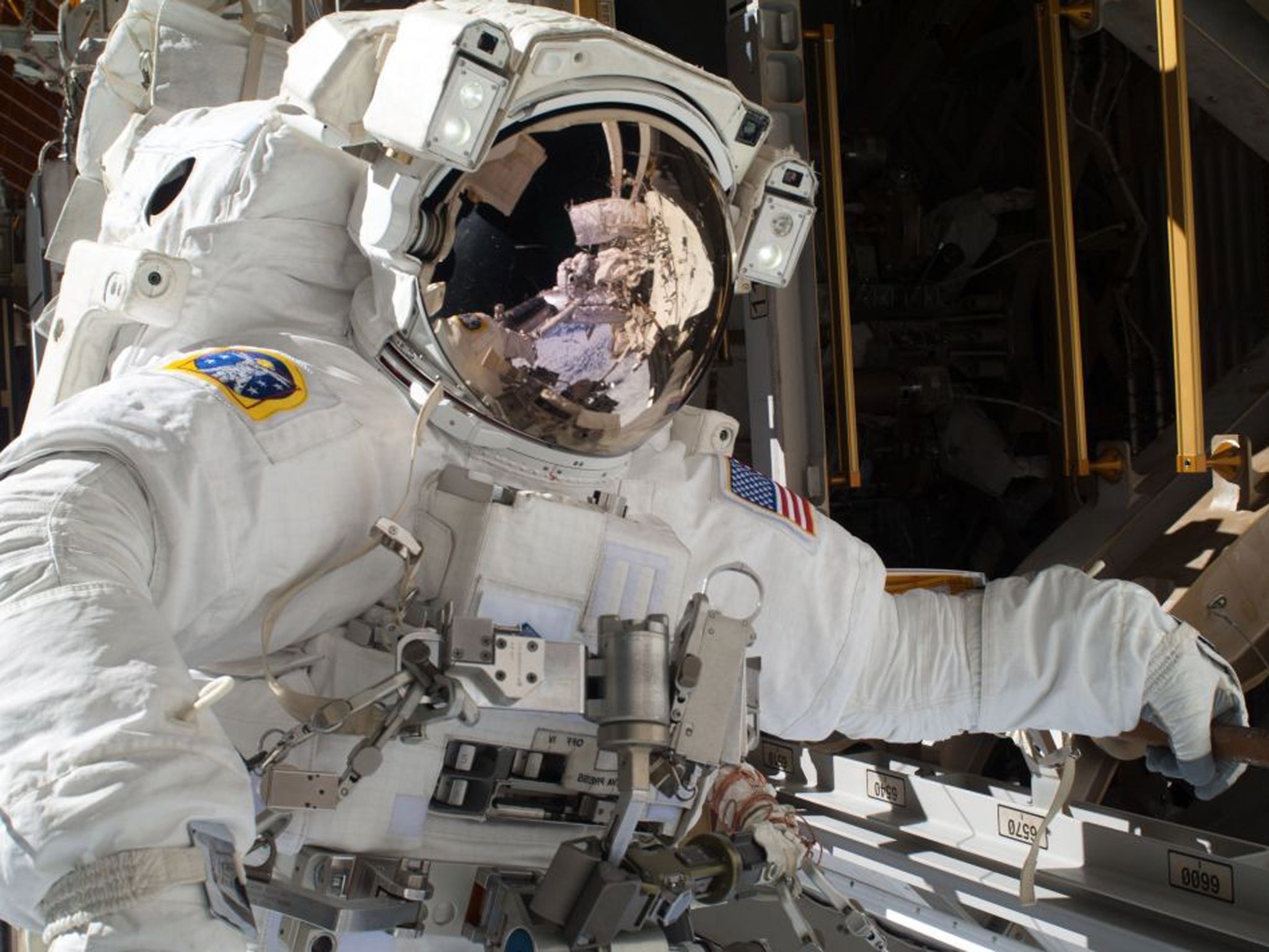 Nasa astronaut Michael Hopkins works to repair an external cooling line on the International Space Station