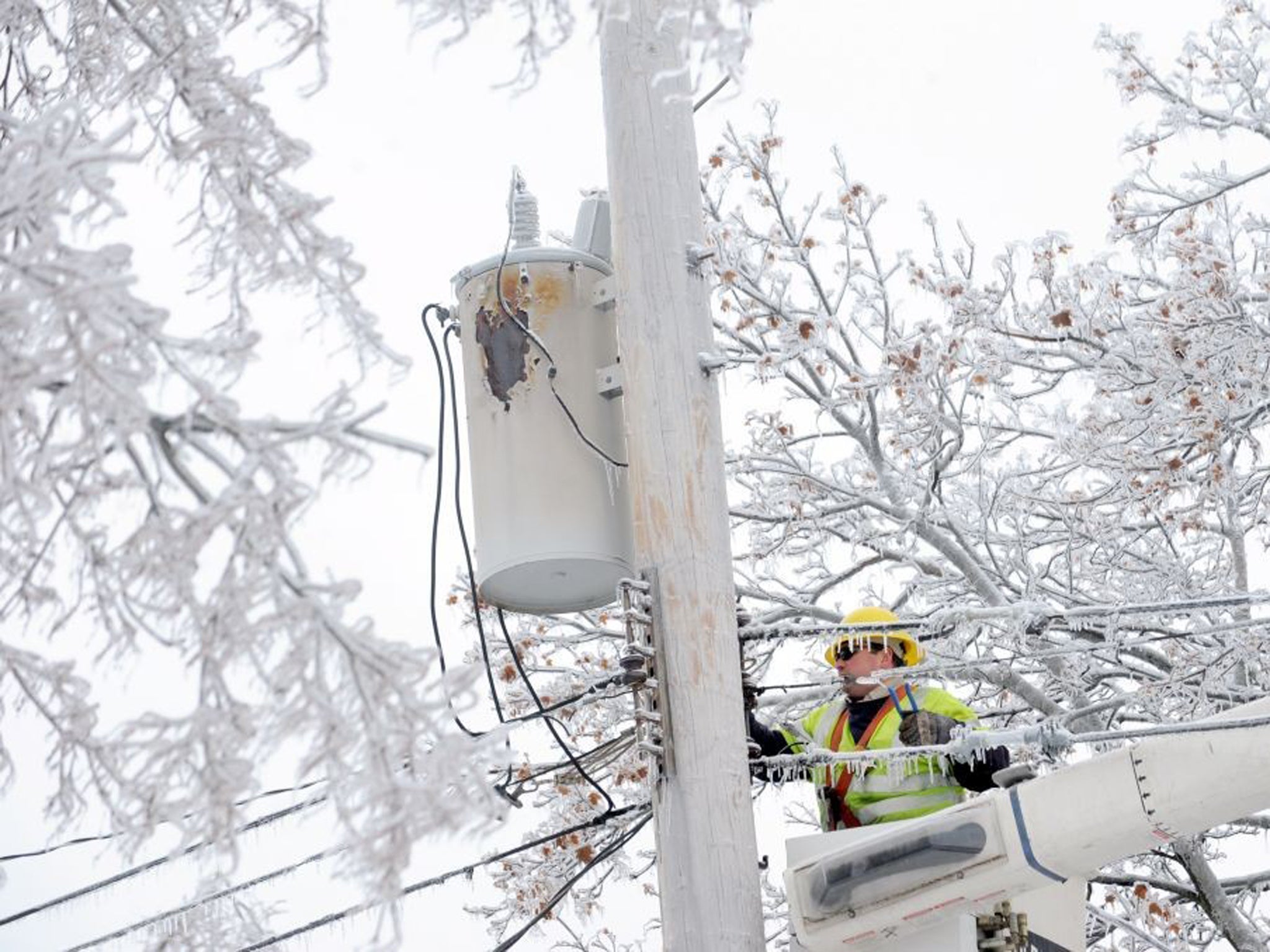 A lineman works on connecting fallen wires in Michigan