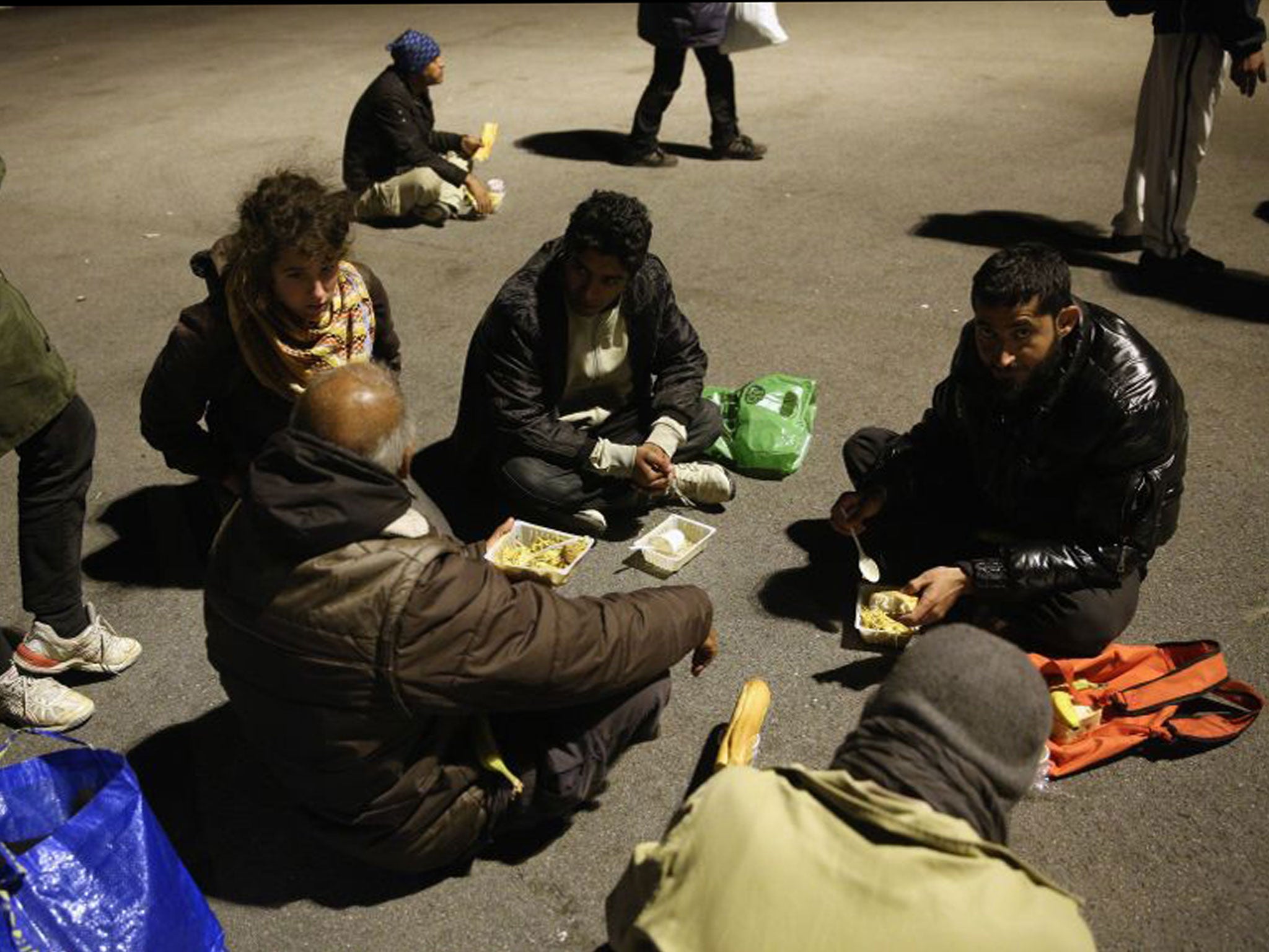 Migrants eat their evening meal at a centre run by volunteers in Calais. France has pledged to take 500 Syrian refugees