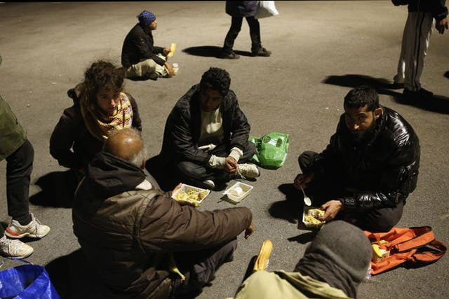 Migrants eat their evening meal at a centre run by volunteers in Calais. France has pledged to take 500 Syrian refugees