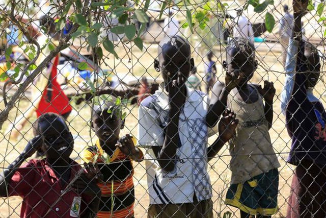 Children displaced by the fighting in South Sudan wait behind the fence of the United Nations Mission facility on the outskirts of the capital Juba. Tens of thousands of refugees have fled the crisis