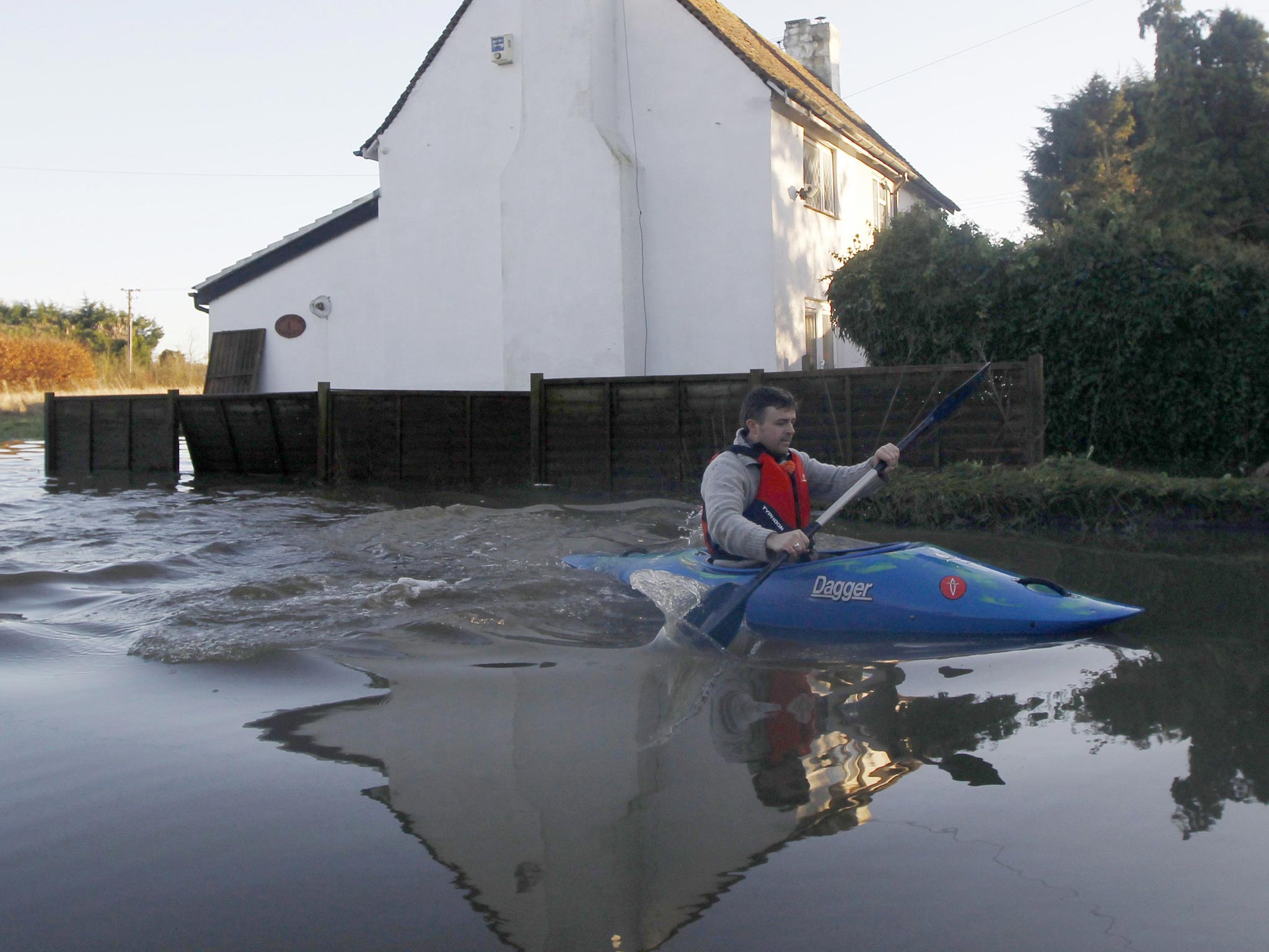 A man paddles through the flood waters in Yalding