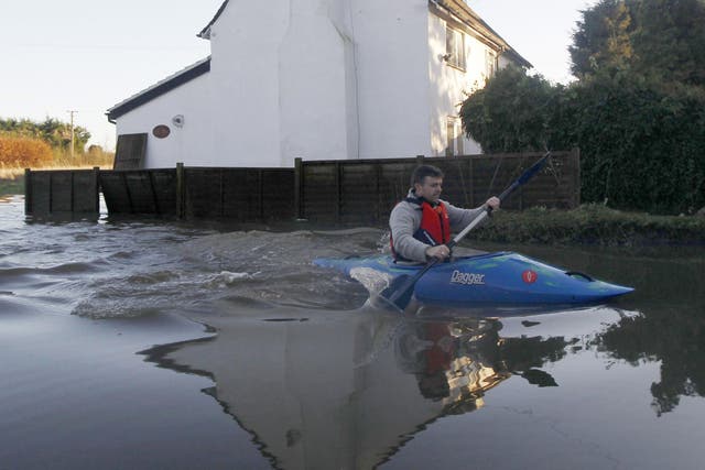 A man paddles through the flood waters in Yalding