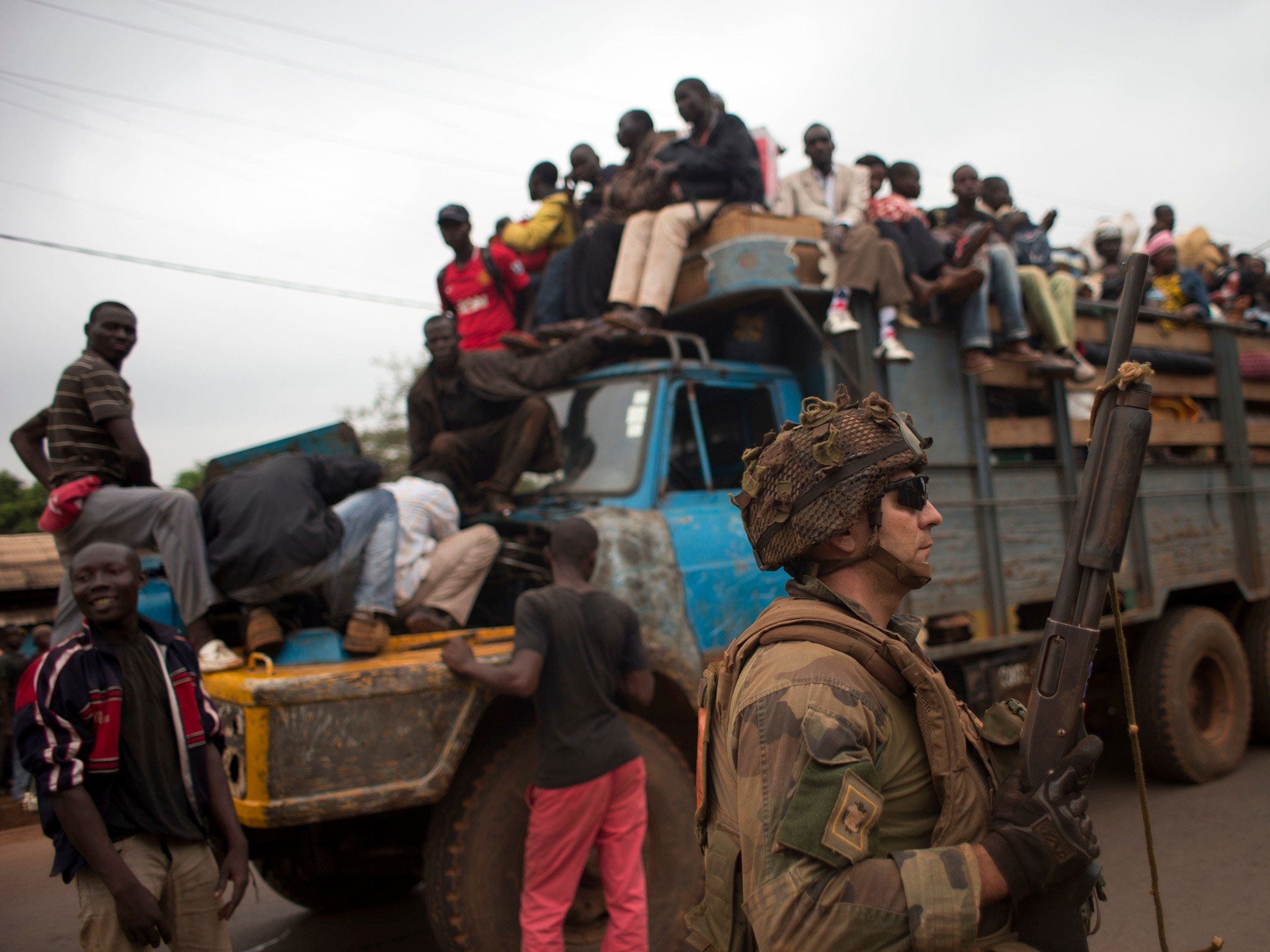 French soldiers protect a truck of fleeing Muslims after it broke down and was surrounded by hundreds of hostile Christian residents in the Gobongo neighborhood of Bangui - Red Cross workers said they had recovered 44 bodies from the streets of the capita