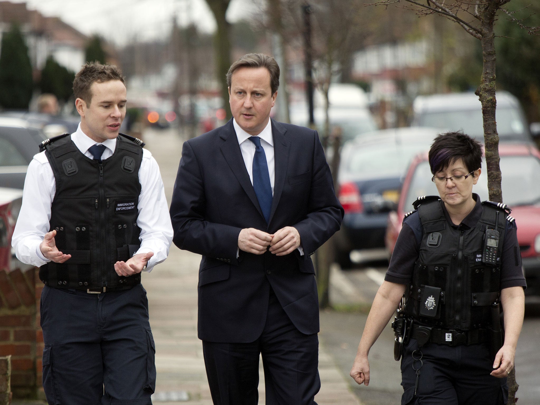 David Cameron visits a house in which was raided by Immigration officers on 18 December. The Prime Minister has been urged to tone down his language when talking about immigration as it is believed to alienate voters