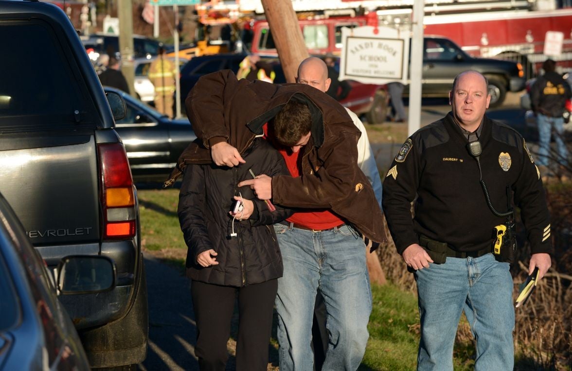 Gun horror: People leave the scene after the school shooting in Connecticut on 14 December 2012