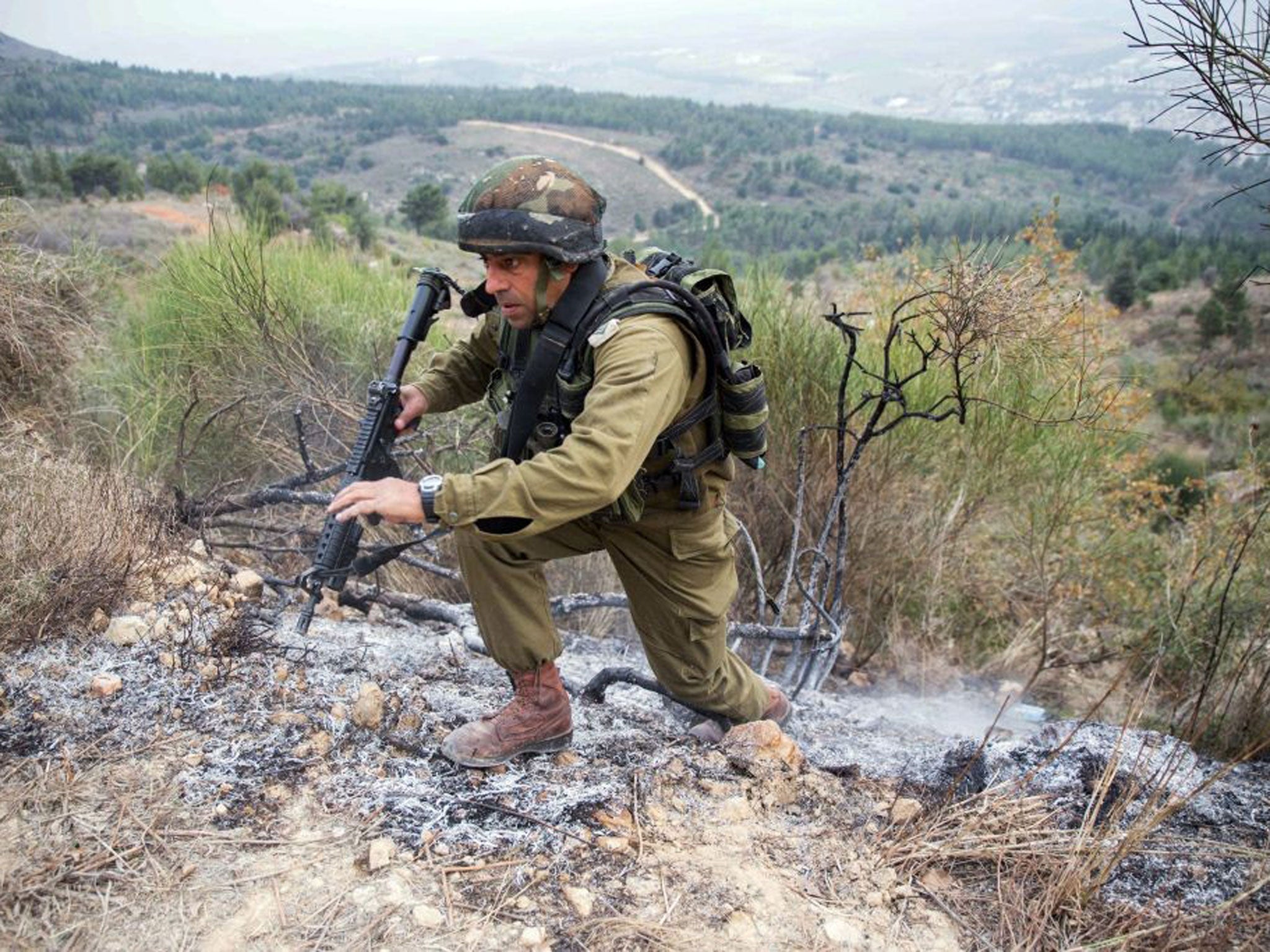 An Israeli army officer inspects the area where a Katyusha rocket fired from militants inside southern Lebanon landed along Israel's northern border to the west of Kiryat Shemona