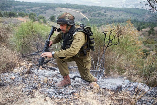 An Israeli army officer inspects the area where a Katyusha rocket fired from militants inside southern Lebanon landed along Israel's northern border to the west of Kiryat Shemona