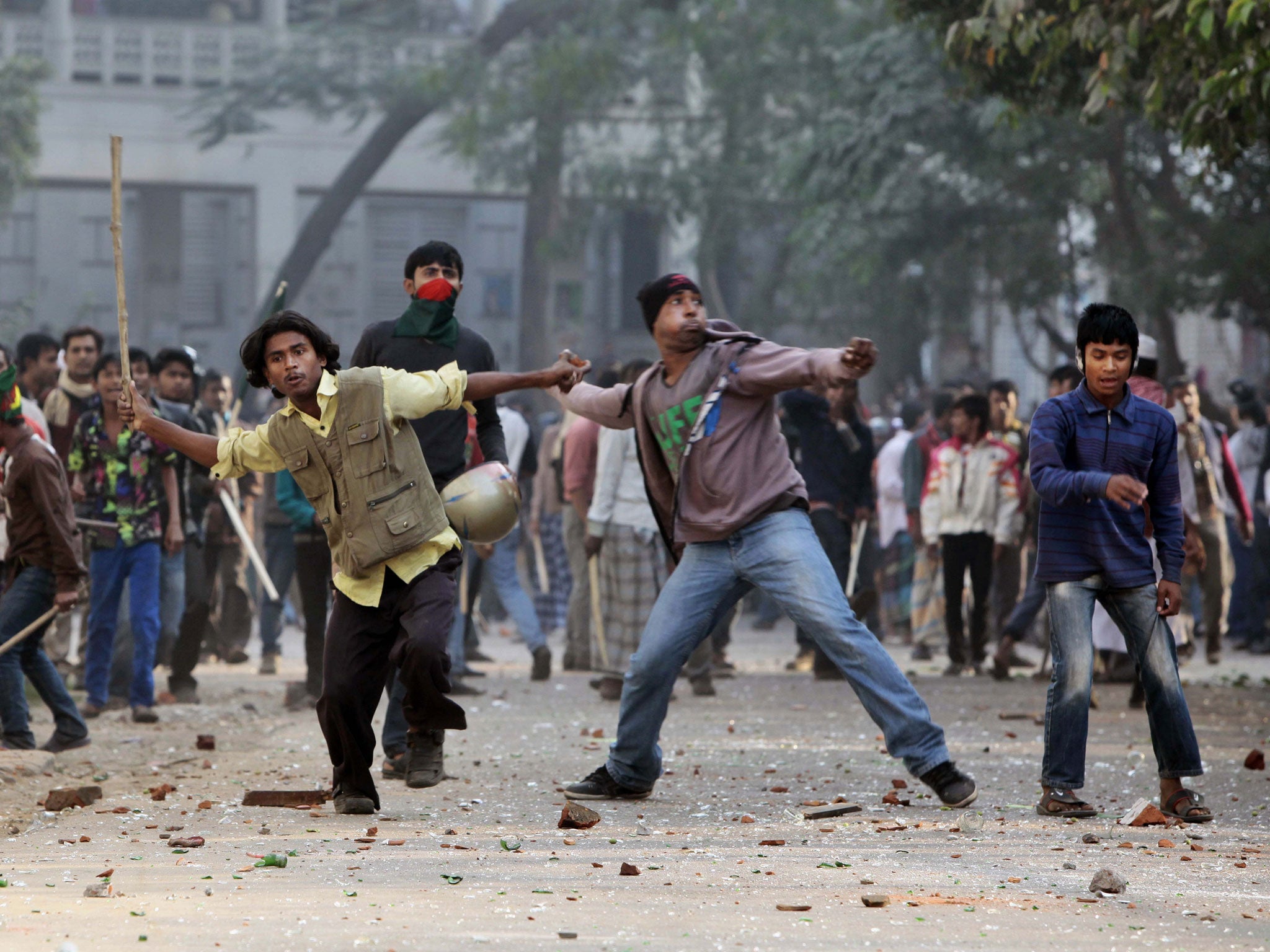 Supporters of the ruling Bangladesh Awami League throw bricks and stones during a clash with the supporters of main opposition Bangladesh Nationalist Party