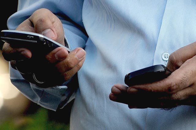 Indian officegoer checks a text message on his mobile phone in Mumbai on September 27, 2011. India's telecom watchdog the Telecom Regulatory Authority of India (TRAI) exempted various service providers, including the dealers of telecom operators, e-ticket