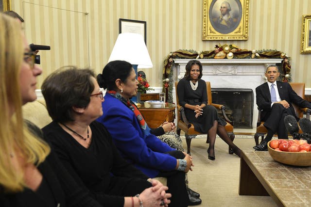 President Barack Obama, with Michelle Obama, listens to women's concerns about the Affordable Care Act, known as 'Obamacare'