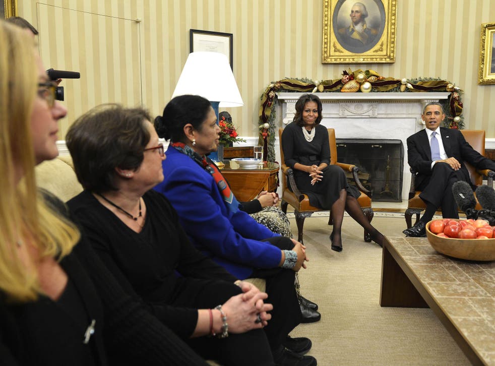 President Barack Obama, with Michelle Obama, listens to women's concerns about the Affordable Care Act, known as 'Obamacare'