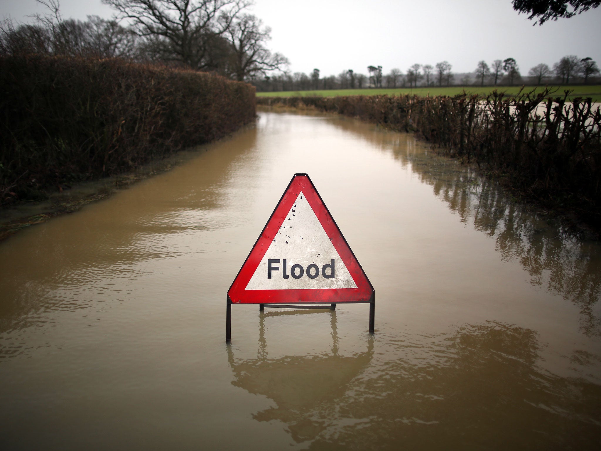 A sign sits in flood water on a road in southern England.