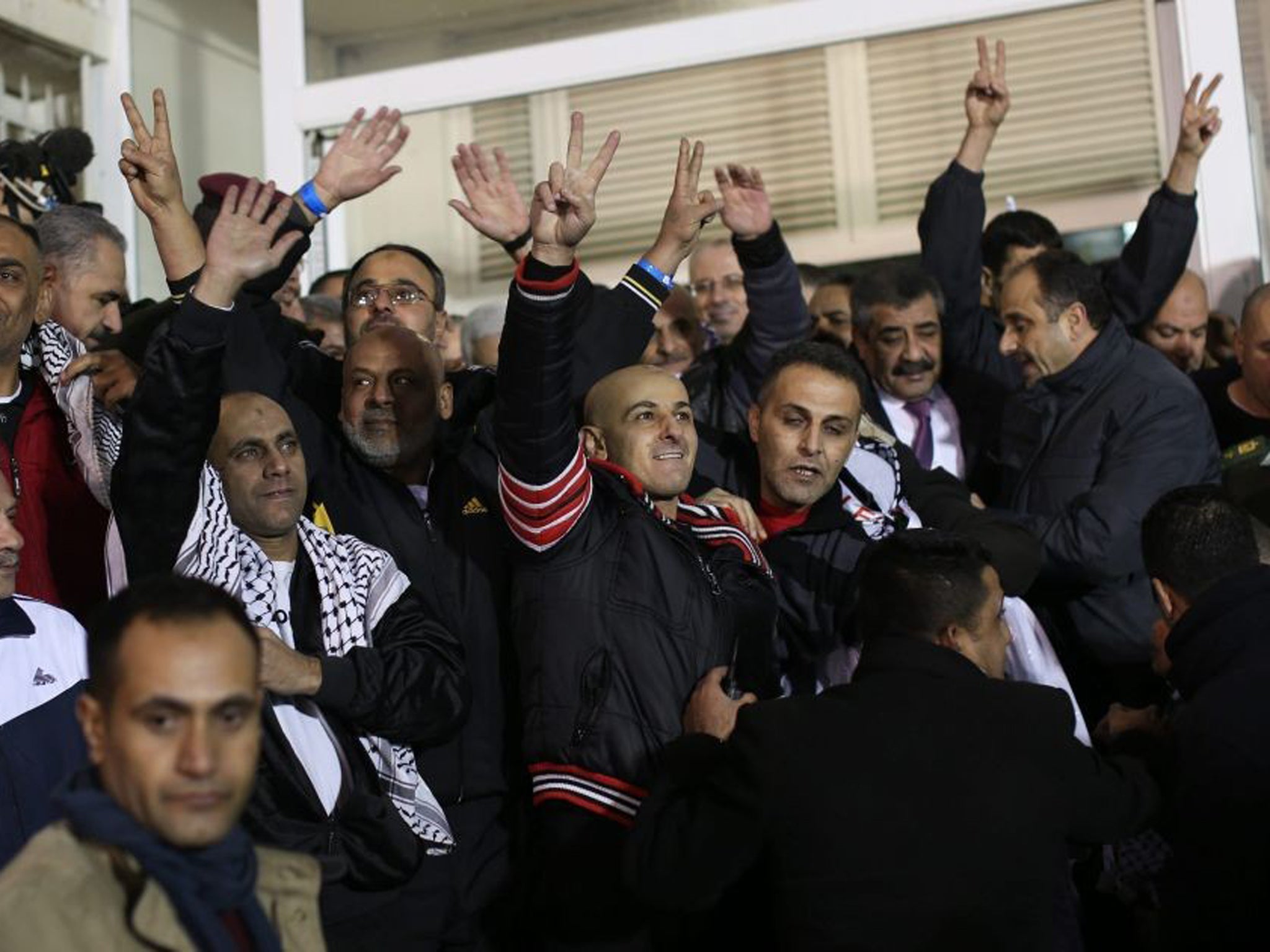 Released Palestinian prisoners gesture the V sign during a welcome ceremony at President Mahmoud Abbas' headquarters in Ramallah, West Bank