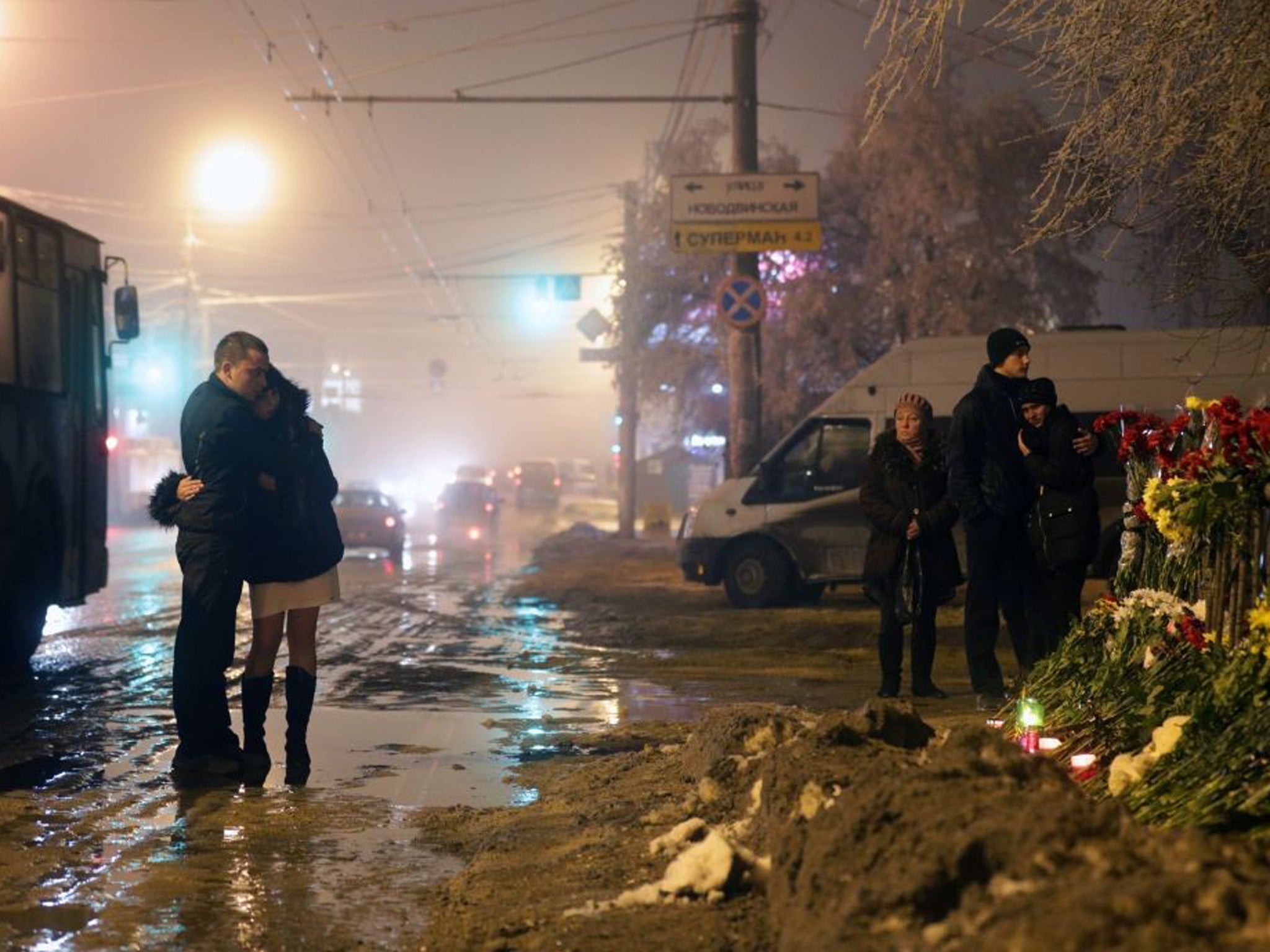 Russian people grieve at the site of the second terrorist explosion, which happened on a trolleybus, at a street in Volgograd