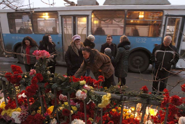 People gather at the site of an explosion on a trolley bus in Volgograd. President Vladimir Putin has vowed to annihilate 'terrorists' following two deadly bomb attacks in less than 24 hours 