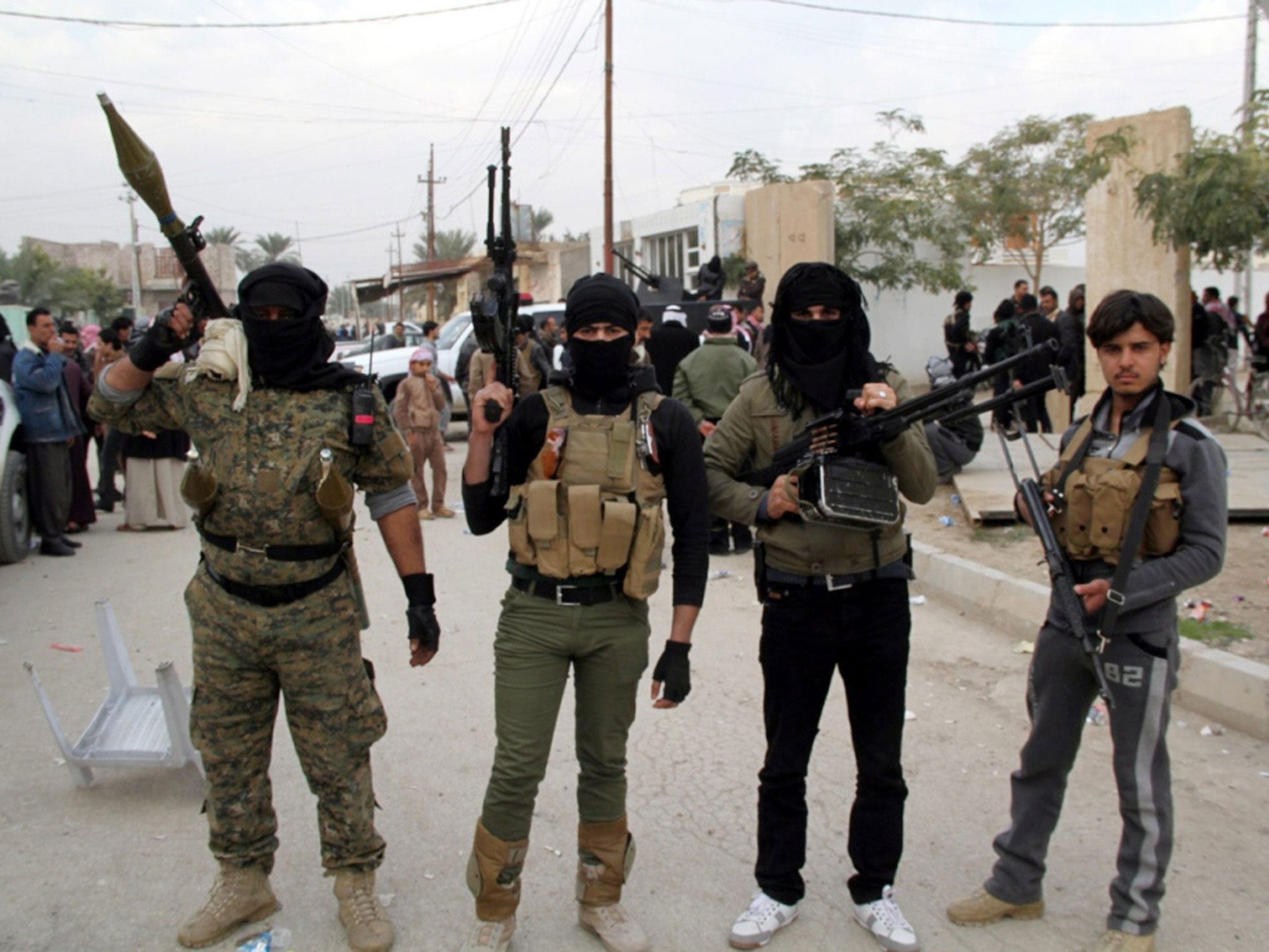 Masked Sunni fighters in Ramadi on Sunday following raids by government forces