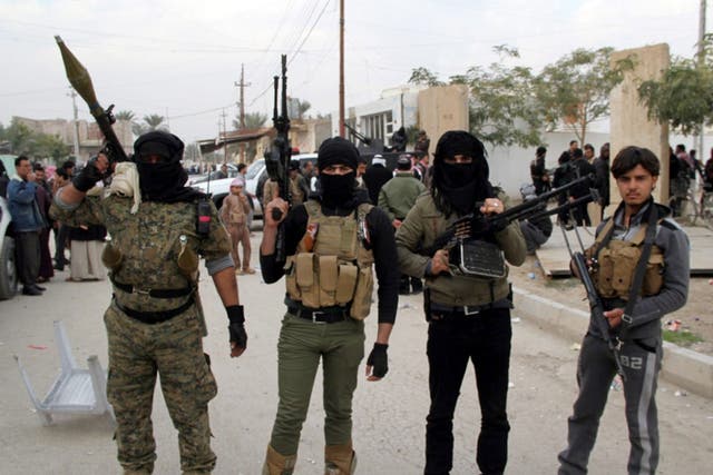 Masked Sunni fighters in Ramadi on Sunday following raids by government forces 