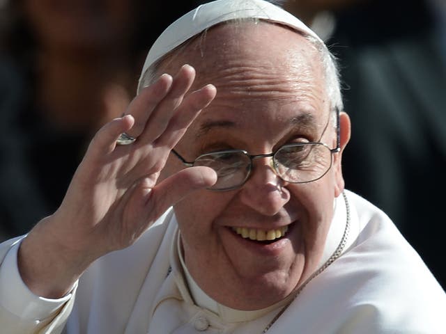 Pope Francis wears his spectacles as he waves to the crowd