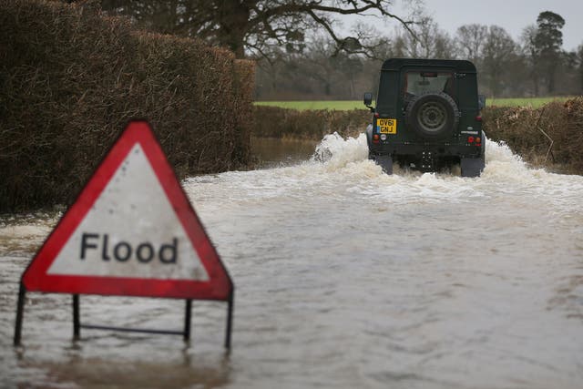 A Landrover makes it's way along a flooded road near Lingfield 