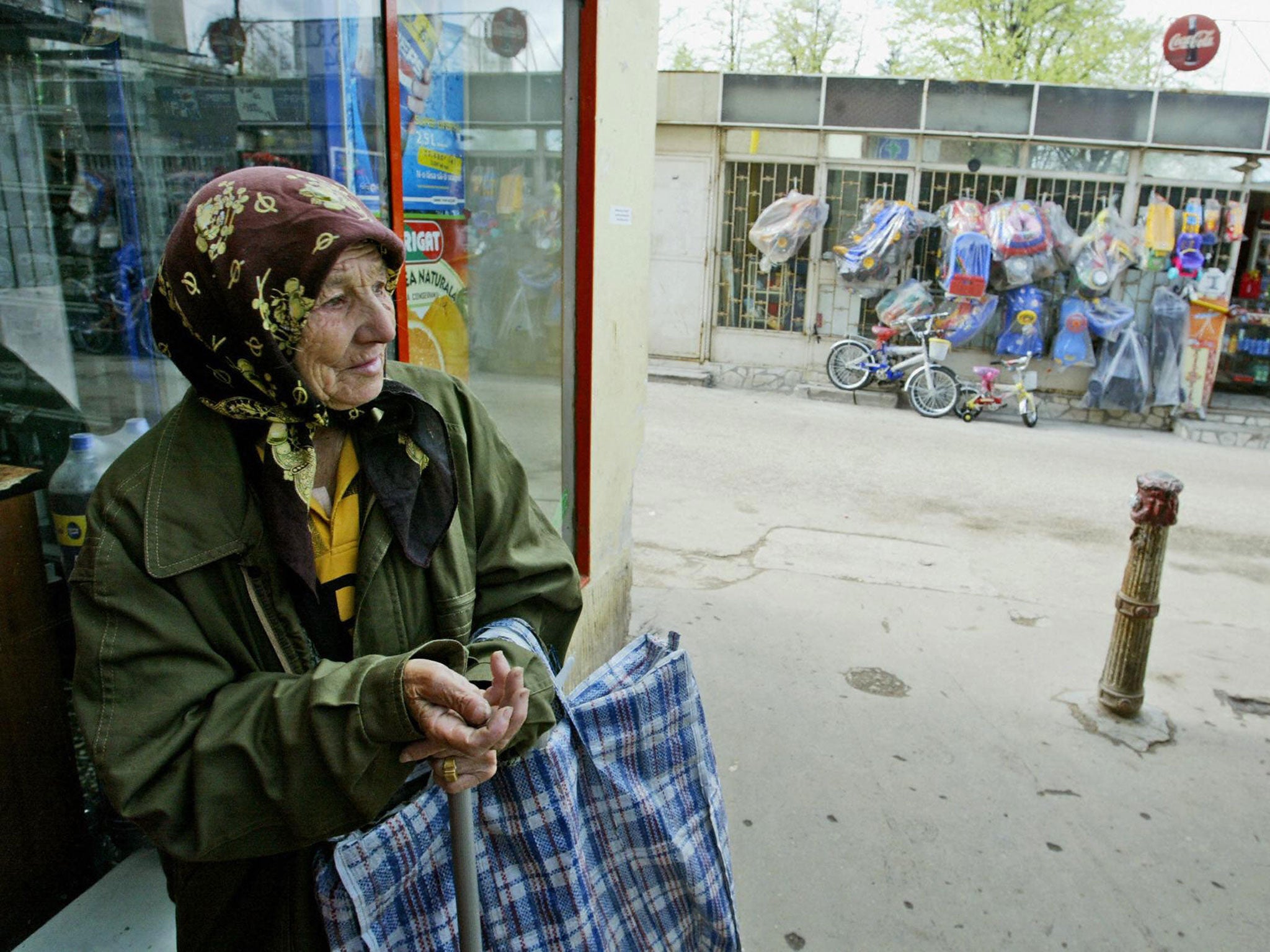 A Romanian woman beggar waits in the front of a shop near Piata Sudului market place in Bucharest.