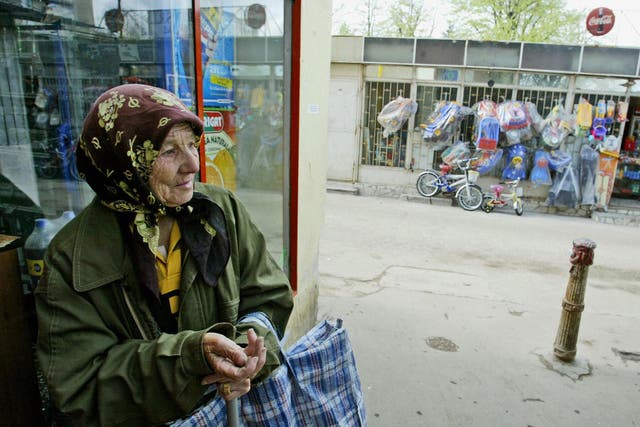  A Romanian woman beggar waits in the front of a shop near Piata Sudului market place in Bucharest.