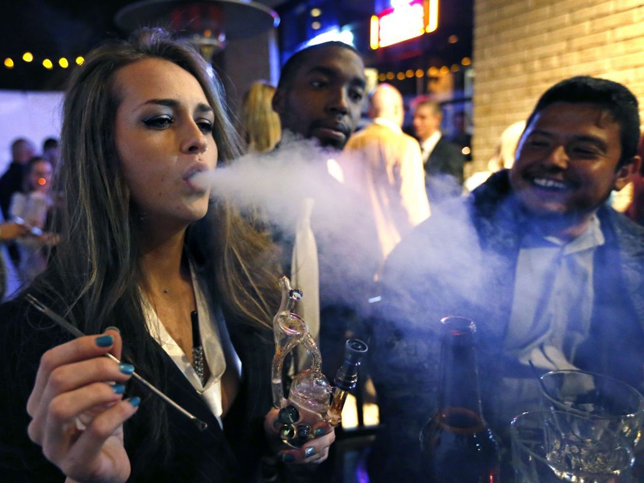 Partygoers smoke marijuana during a Prohibition-era themed New Year's Eve party celebrating the start of retail cannabis sales