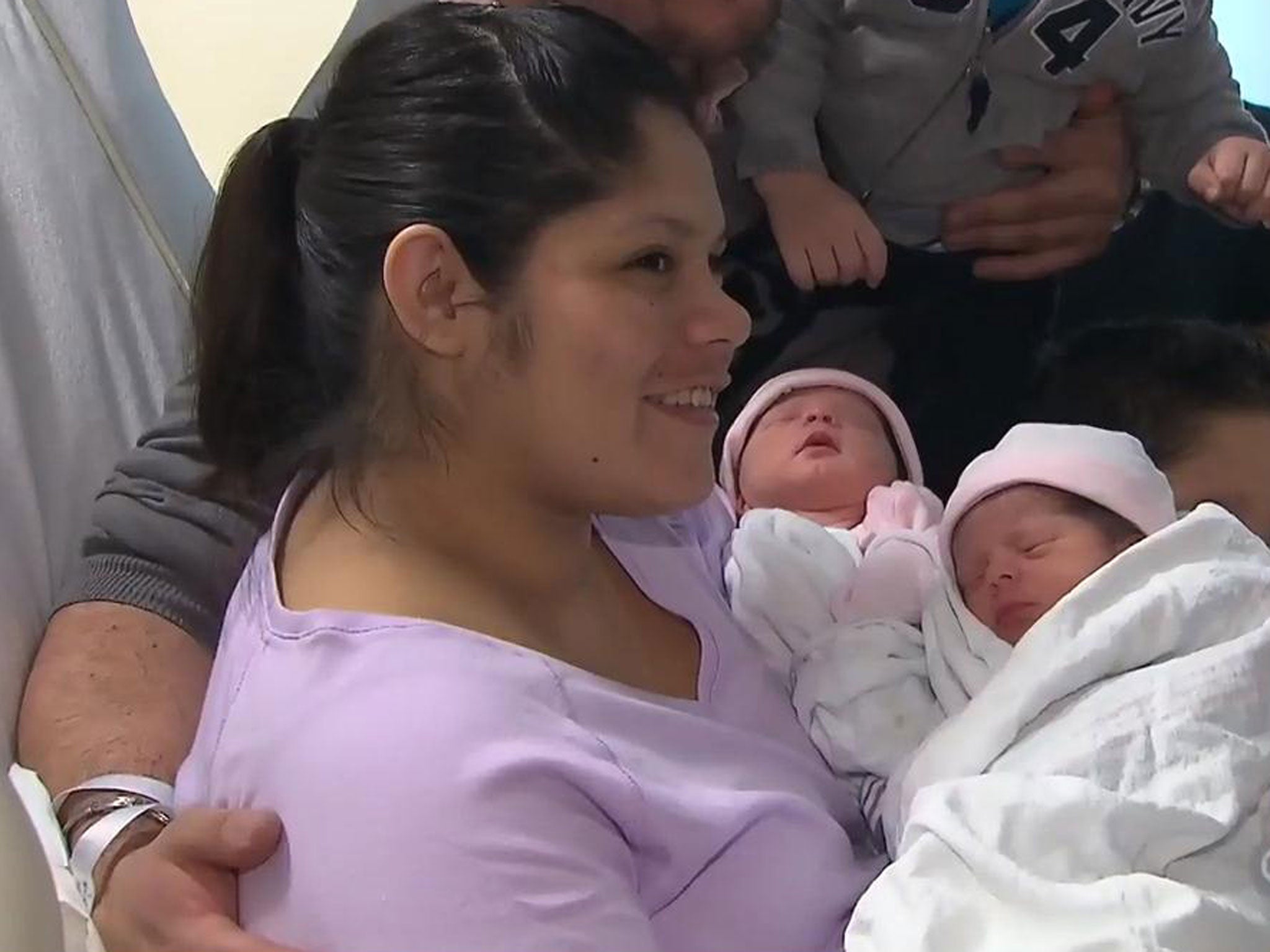 Ms Salgueiro holding her twin daughters, who were born in separate years