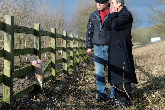 Ali Aydi, right, the uncle of Rania Alayed and a friend put flowers at a layby next to the A19 near Thirsk in North Yorkshire 