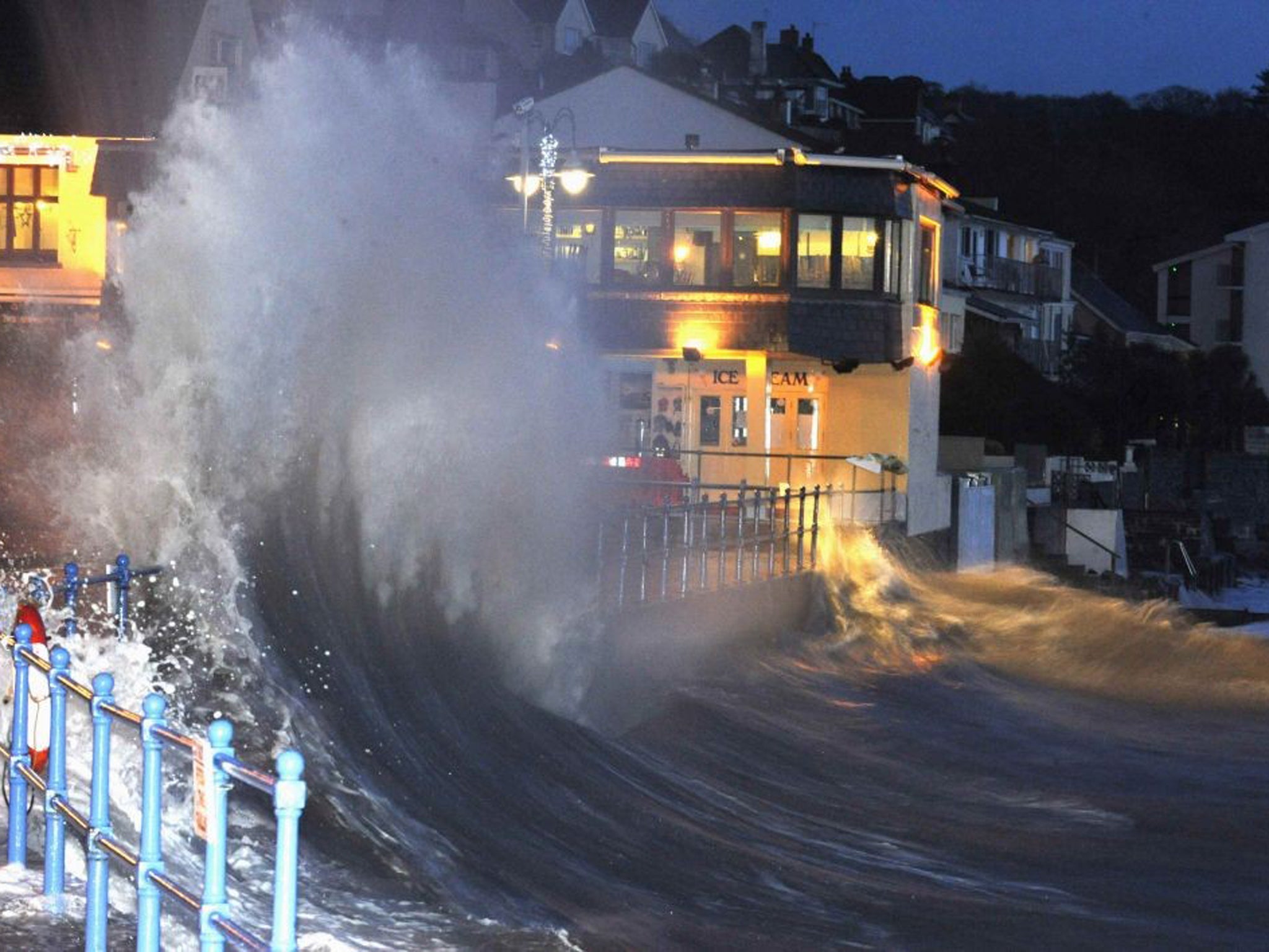 Waves crash over the promenade at hightide in Saundersfoot, in west Wales