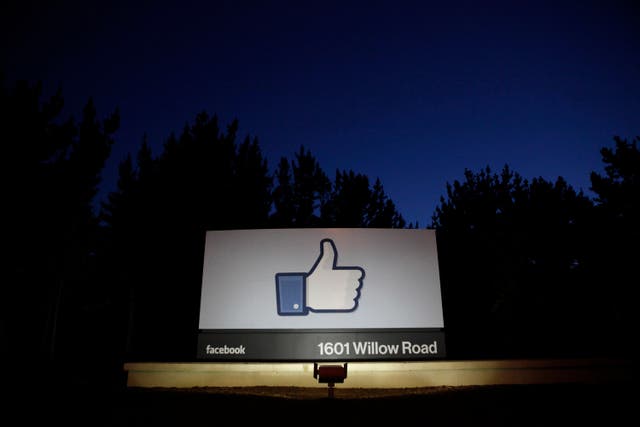 The sun rises behind the entrance sign to Facebook headquarters in Menlo Park.