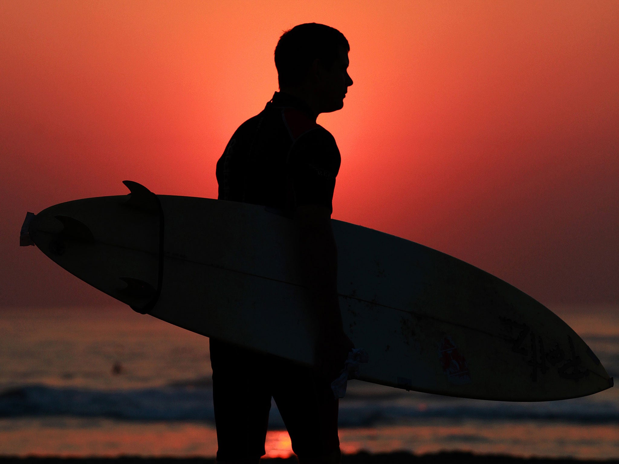 A surfer heads out to catch the early morning waves in Durban