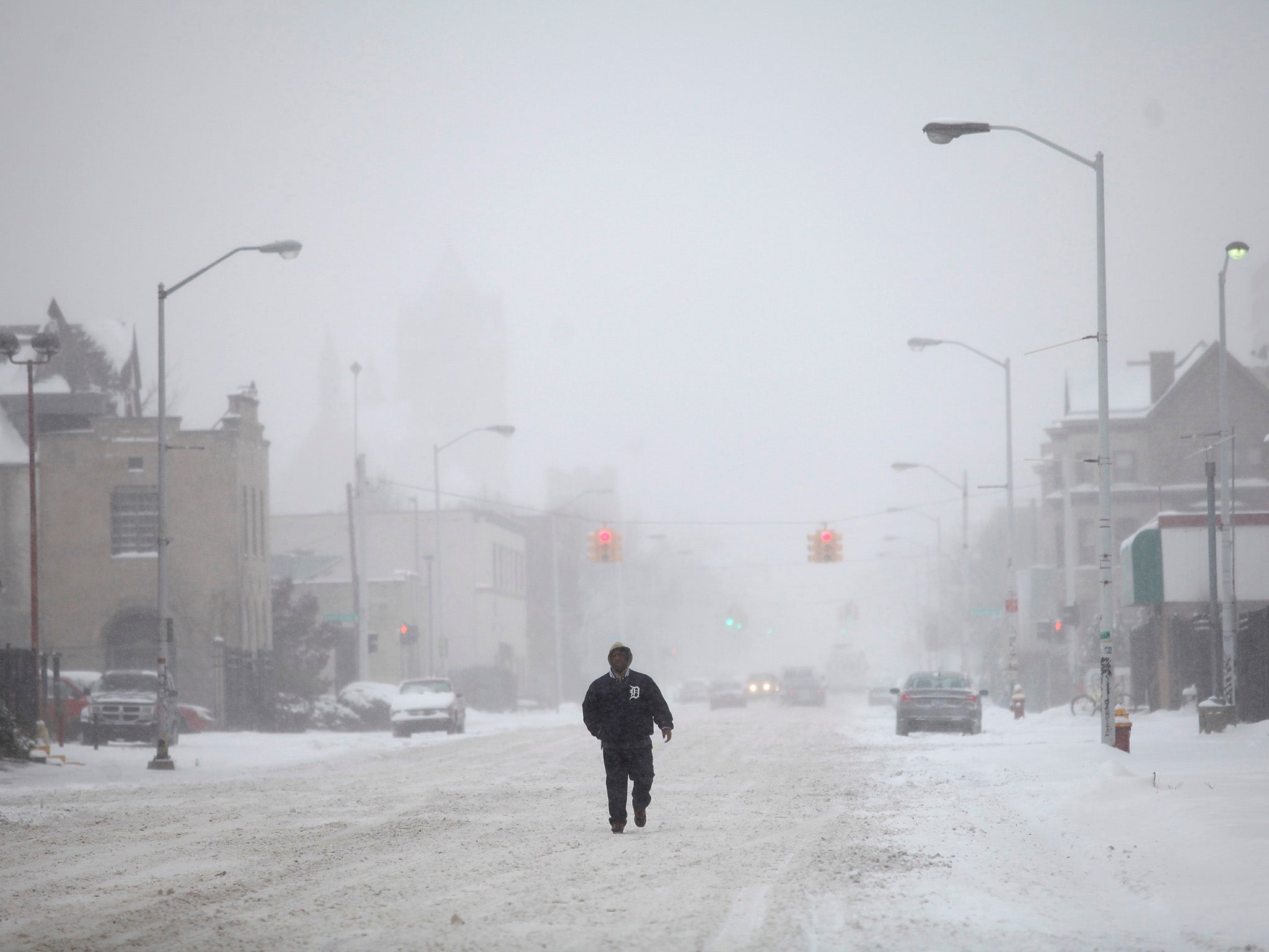 A man walks along a snow covered Cass Avenue in Detroit, Michigan. The first major winter storm of 2014 bore down on the US northeast on Thursday and Friday with heavy snow, Arctic temperatures and strong winds