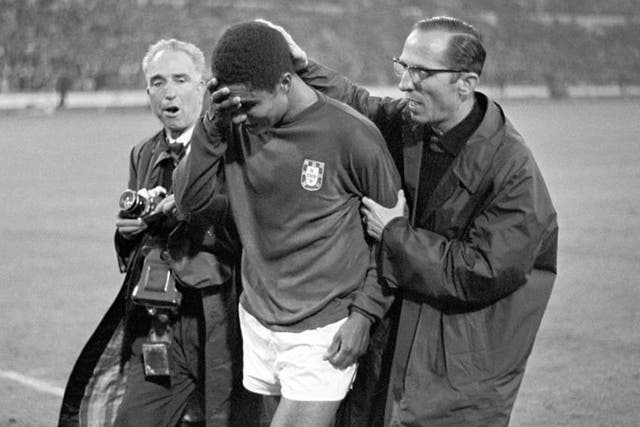 Portugal's Eusebio being consoled by a compatriot as he leaves the field in tears after Portugal had been defeated 1-2 by England in the 1966 World Cup semi-final at Wembley