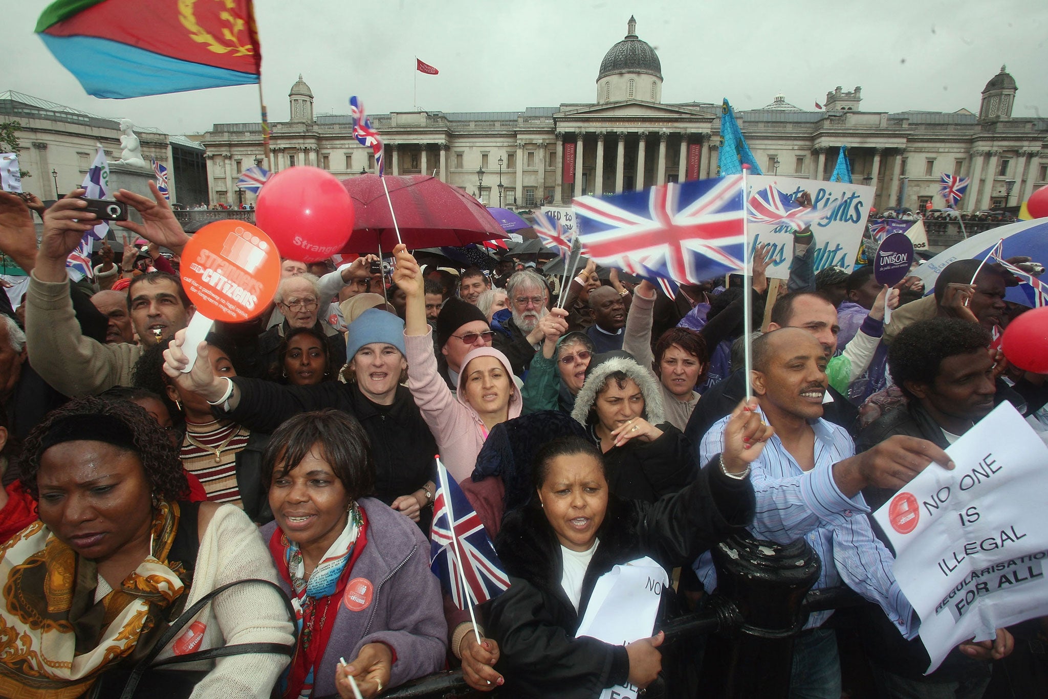 Protestors cheer, wave flags and banners during a march hoping to draw attention to claims of exploitation and discrimination of migrant workers