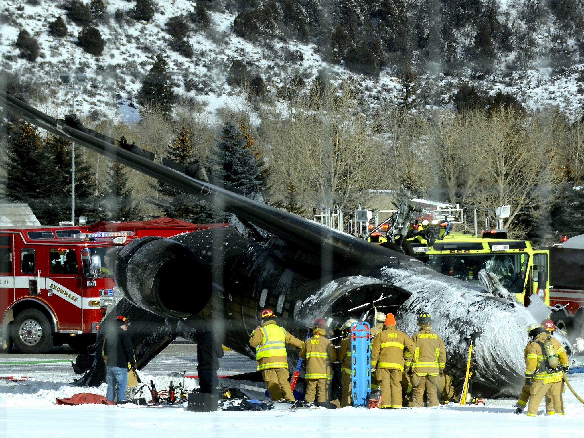 Emergency crews work near a passenger plane that crashed upon landing at the Aspen-Pitkin County Airport in Aspen, Colorado