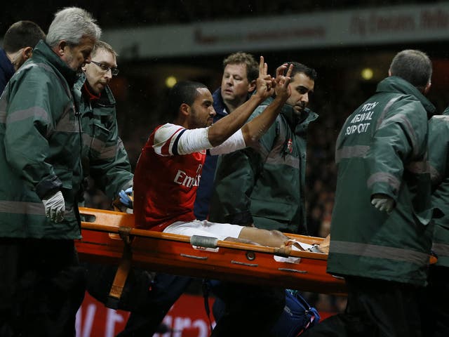 Arsenal’s Theo Walcott makes the ‘2-0’ gesture to Spurs fans as he is carried off