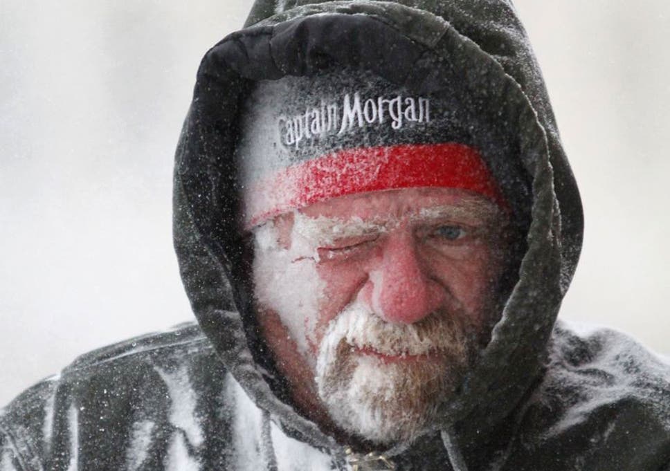 Allan Umscheid, owner of Yards By Al in Lawrence, Kan, feels the bitter wind and catches drifting snow on his face as he runs a snow blower early morning