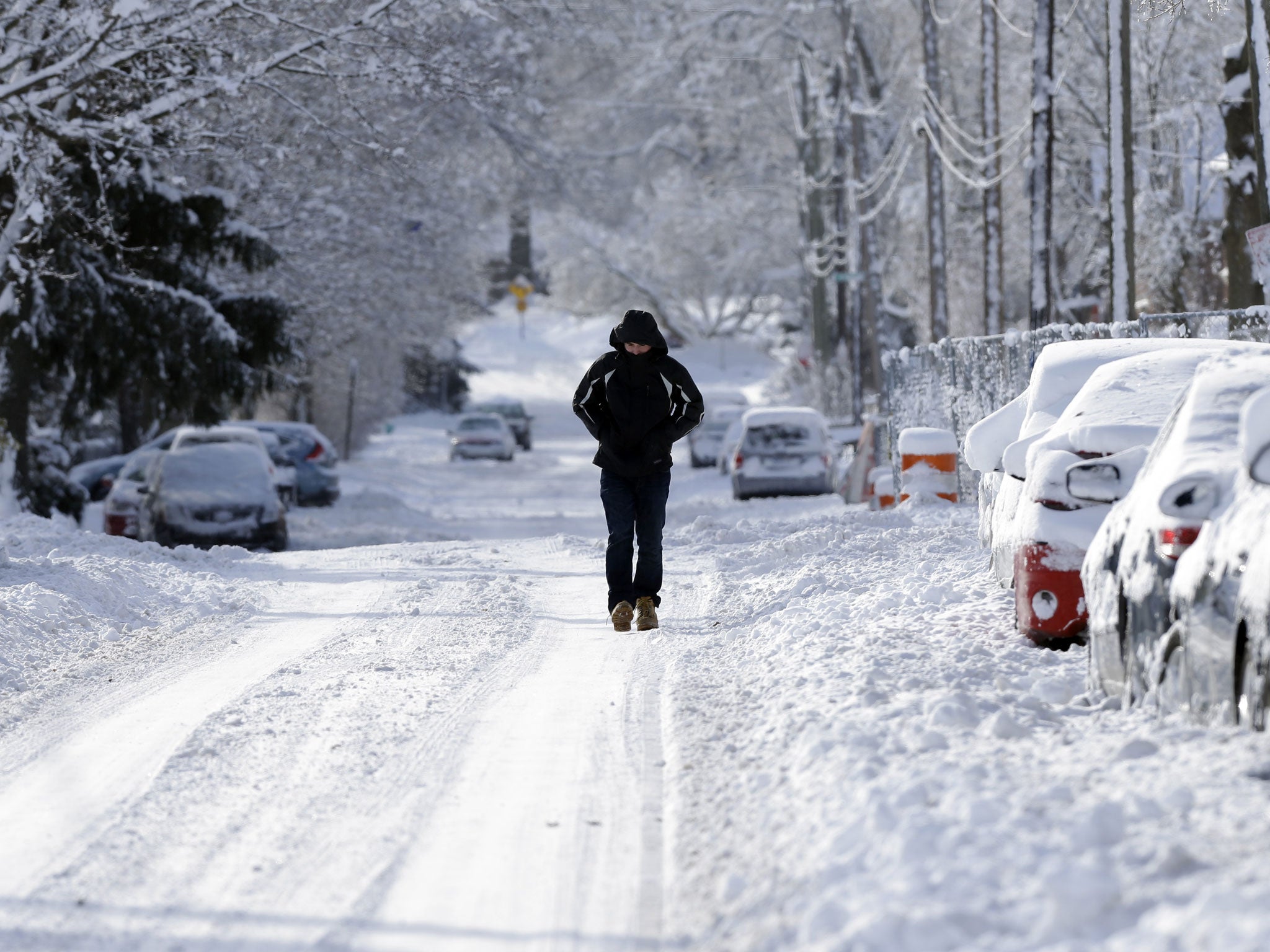 A pedestrian makes their way along a snow packed street in Indianapolis