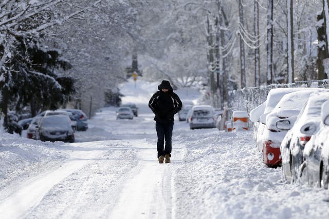 A pedestrian makes their way along a snow packed street in Indianapolis