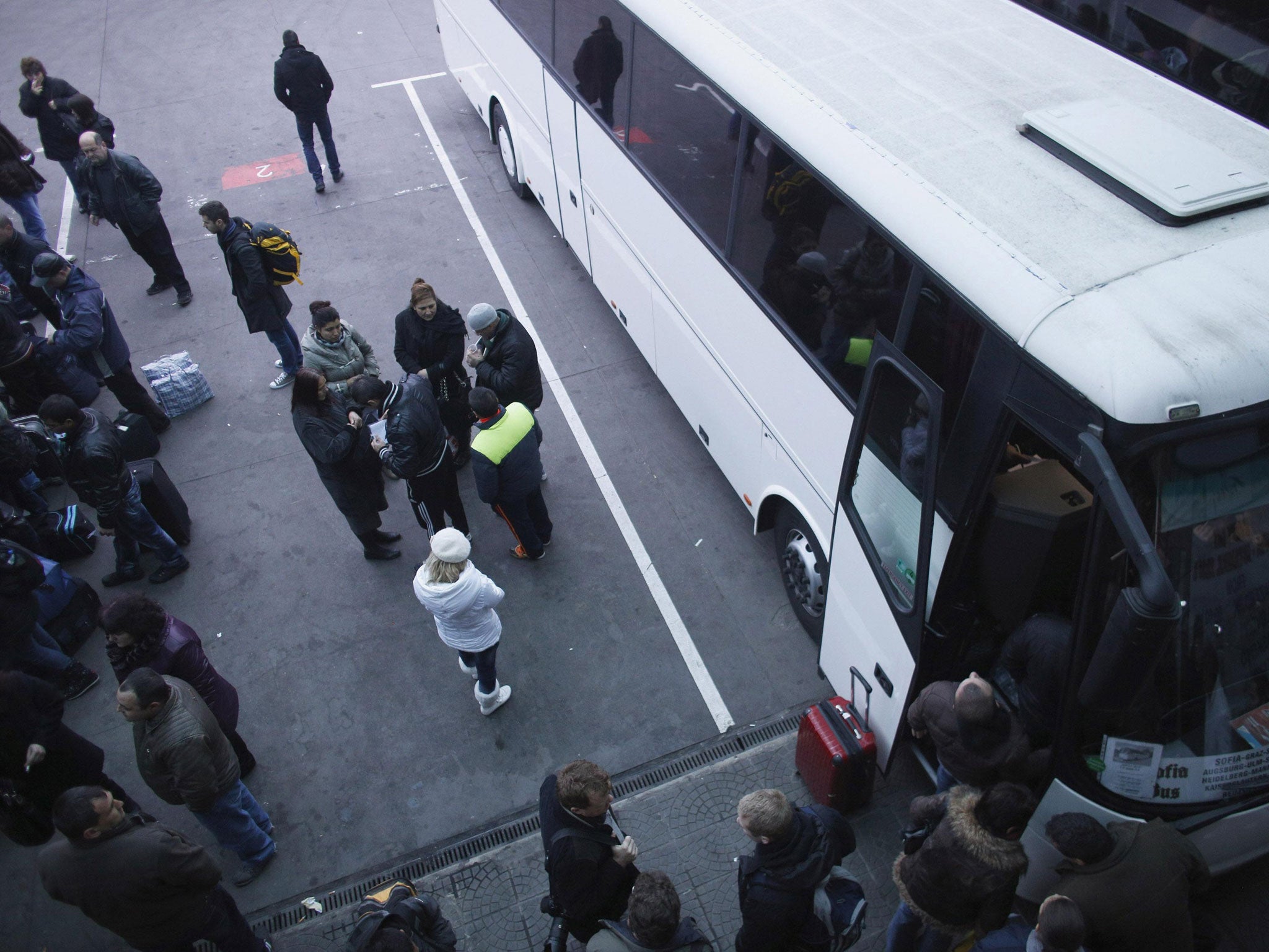 People stand next to a bus departing from Sofia's central bus station headed to London. Hostility to the current scale of immigration is increasing among the British public
