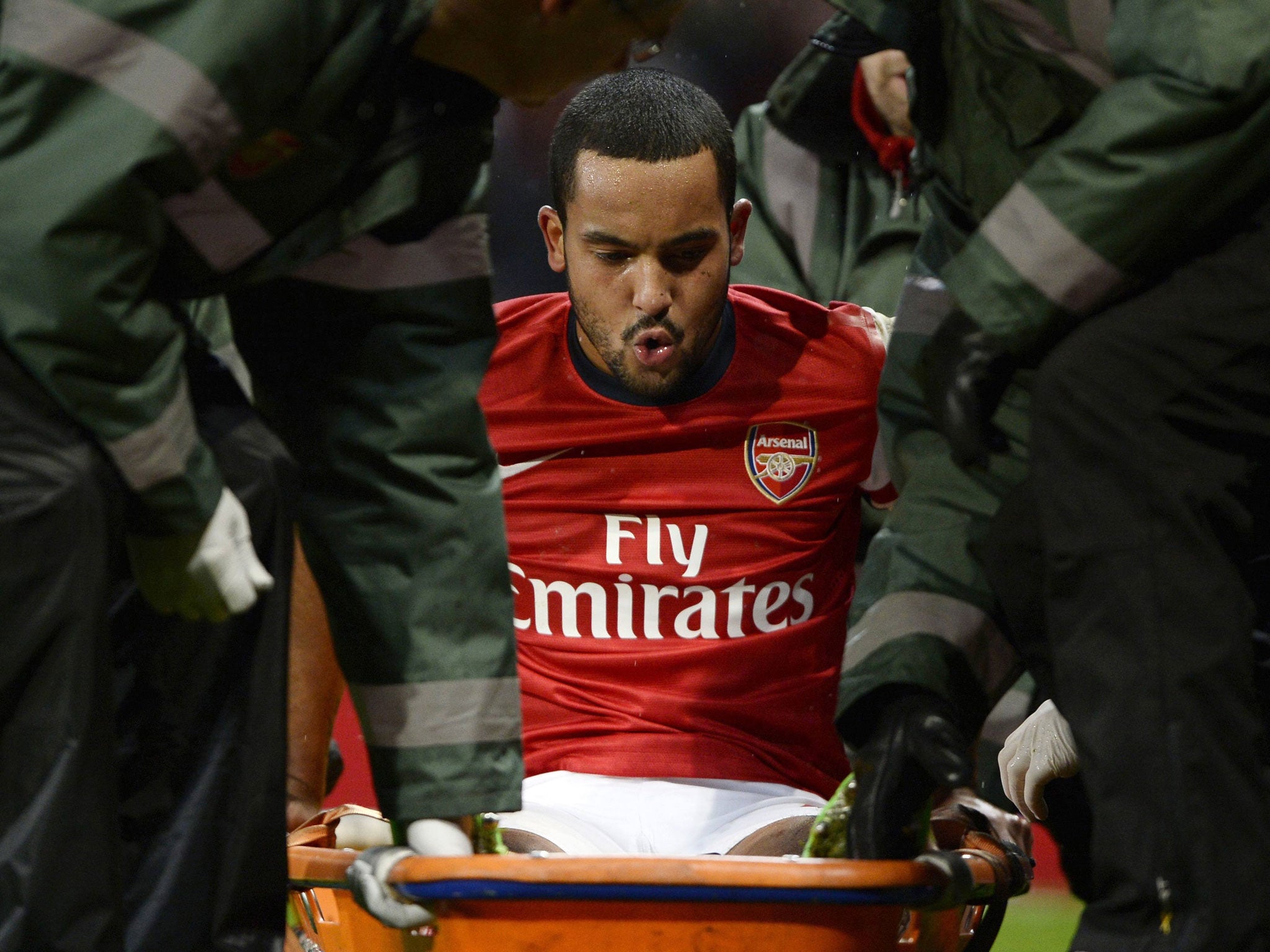 Theo Walcott is stretchered off the pitch during the match against Tottenham Hotspur