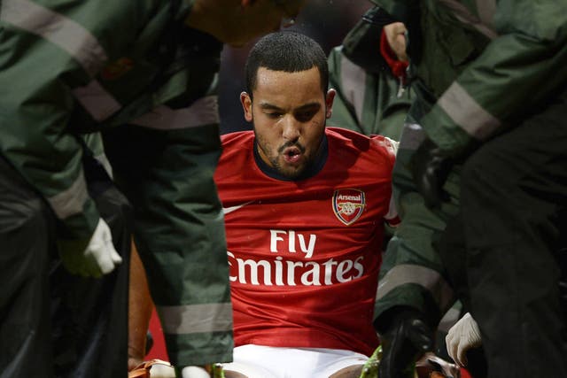 Theo Walcott is stretchered off the pitch during the match against Tottenham Hotspur 