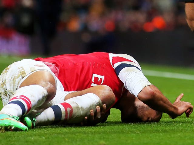 Theo Walcott lies injured on the pitch in Arsenal's FA Cup victory over Tottenham
