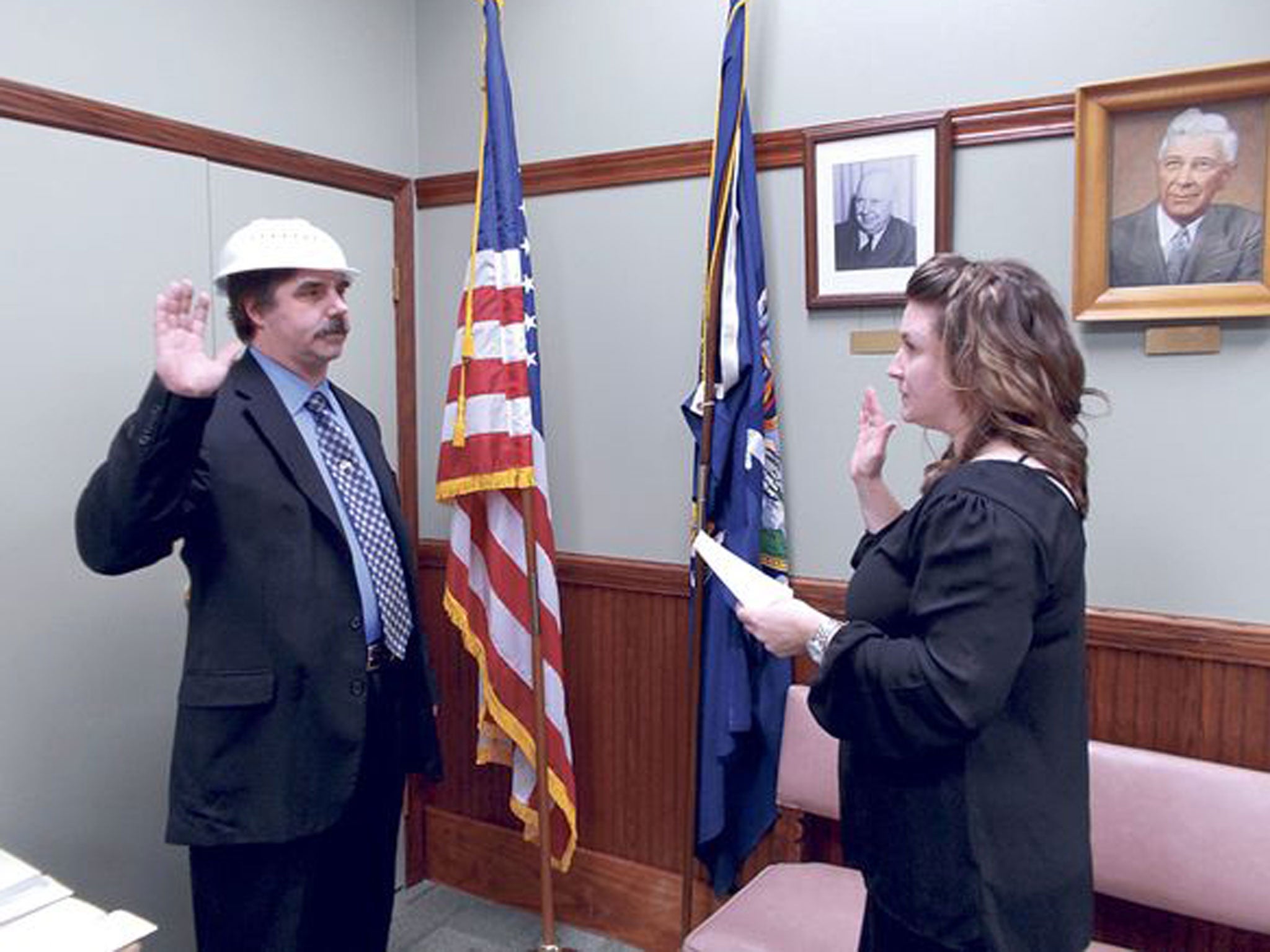 Newly-seated Pomfret Town Council member Christopher Schaeffer (left) recites the oath of office read to him by Town Clerk Allison Dispense. Schaeffer wore a colander, which is associated with a unique religious movement called the Church of the Flying Spaghetti Monster.