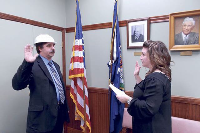 Newly-seated Pomfret Town Council member Christopher Schaeffer (left) recites the oath of office read to him by Town Clerk Allison Dispense. Schaeffer wore a colander, which is associated with a unique religious movement called the Church of the Flying Spaghetti Monster.