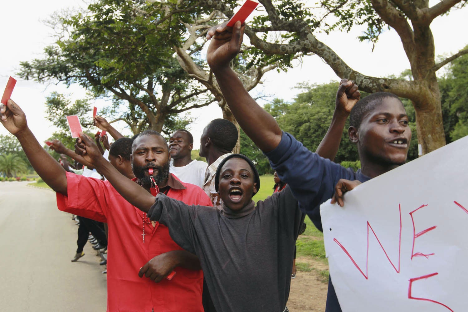 Frank Bwalya, in red, with supporters holding red cards to protest against government in 2011.