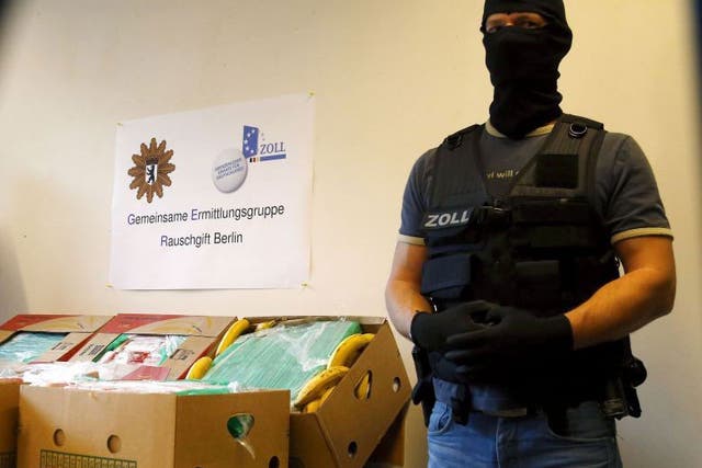 A German police officer poses next to a table laden with the confiscated cocaine
